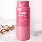 Champú Curl Perfect Deliplus de Mercadona para rizos sobre superficie de mármol con gotitas de agua