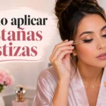 Mujer aplicándose pestañas postizas frente al espejo con productos de maquillaje de Mercadona
